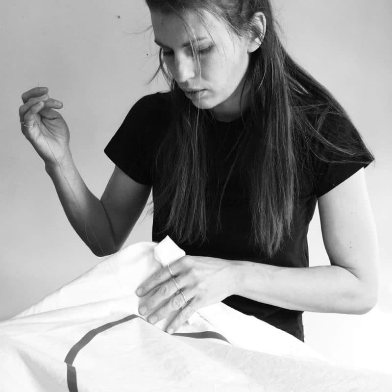 Image of Hannah Fallon sewing one of her flags.